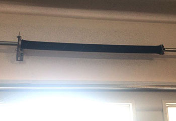 Close-up of broken torsion spring before replacement in Spring Valley home garage