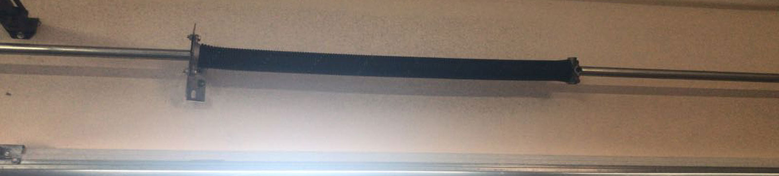 Close-up of broken torsion spring before replacement in Spring Valley home garage