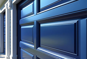 Glossy blue paneled garage door on a residential home, reflecting quality installation and maintenance by local La Mesa specialists.
